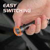 A hand is shown easily switching on a black mini key chain LED flashlight.