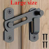 A close-up of a large stainless steel barn door lock mechanism with a lever and two keys mounted on a wooden surface.