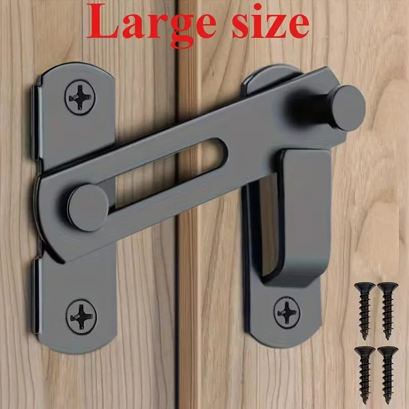 A close-up of a large stainless steel barn door lock mechanism with a lever and two keys mounted on a wooden surface.