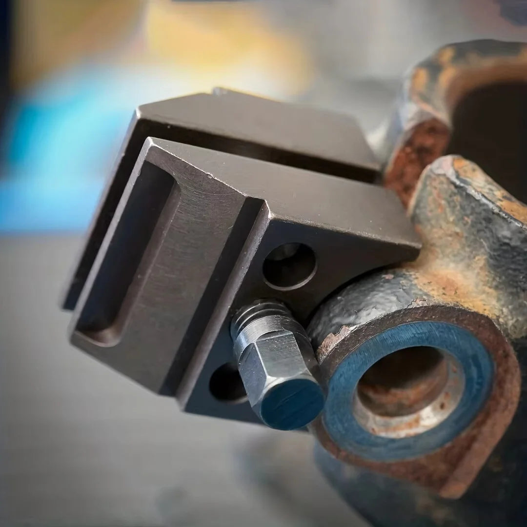 A close-up view of a heavy-duty ball joint disassembly tool, showing a metal jaw and a socket adapter.