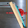 A precision miter gauge with wooden and colored blades is shown against a gray machine surface.