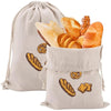 A beige linen drawstring bag filled with various baked goods like bread and rolls.