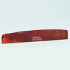 A wooden guitar bone bridge saddle with the inscription Guykor ATR-7632