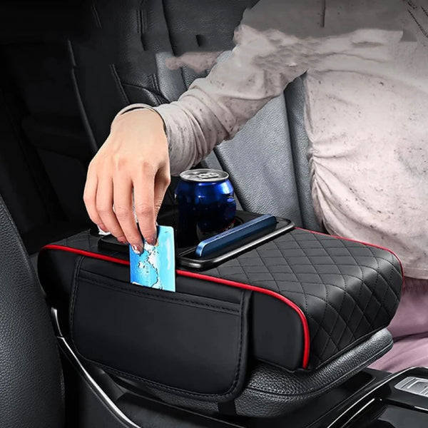 Schwarzer Auto-Armlehnenkissen mit Getränkehaltern auf einem Sitz, wobei eine Hand eine Dose darüber hält.