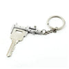 A silver metal jewelry measuring ruler and caliper keychain with a key shape.