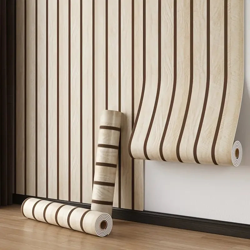 Roll of self-adhesive wood grain wall panels in light beige and brown stripes mounted on a white wall.