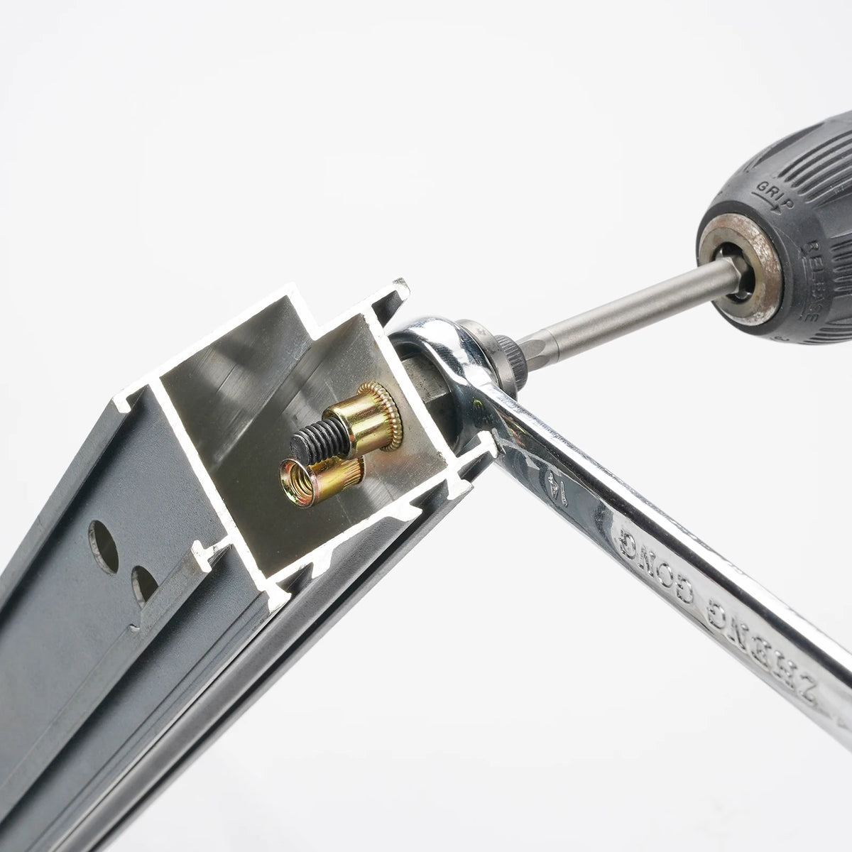 A close-up view of a precision hand rivet nut gun assembly with a metal tool and a rivet nut.