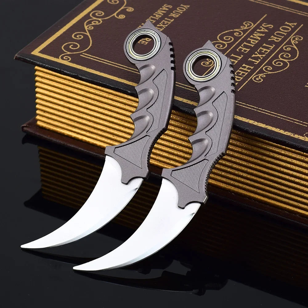 Ein Paar grauer Dragon Claw Modellmesser ruht auf einem Stapel brauner und goldkantiger Bücher.