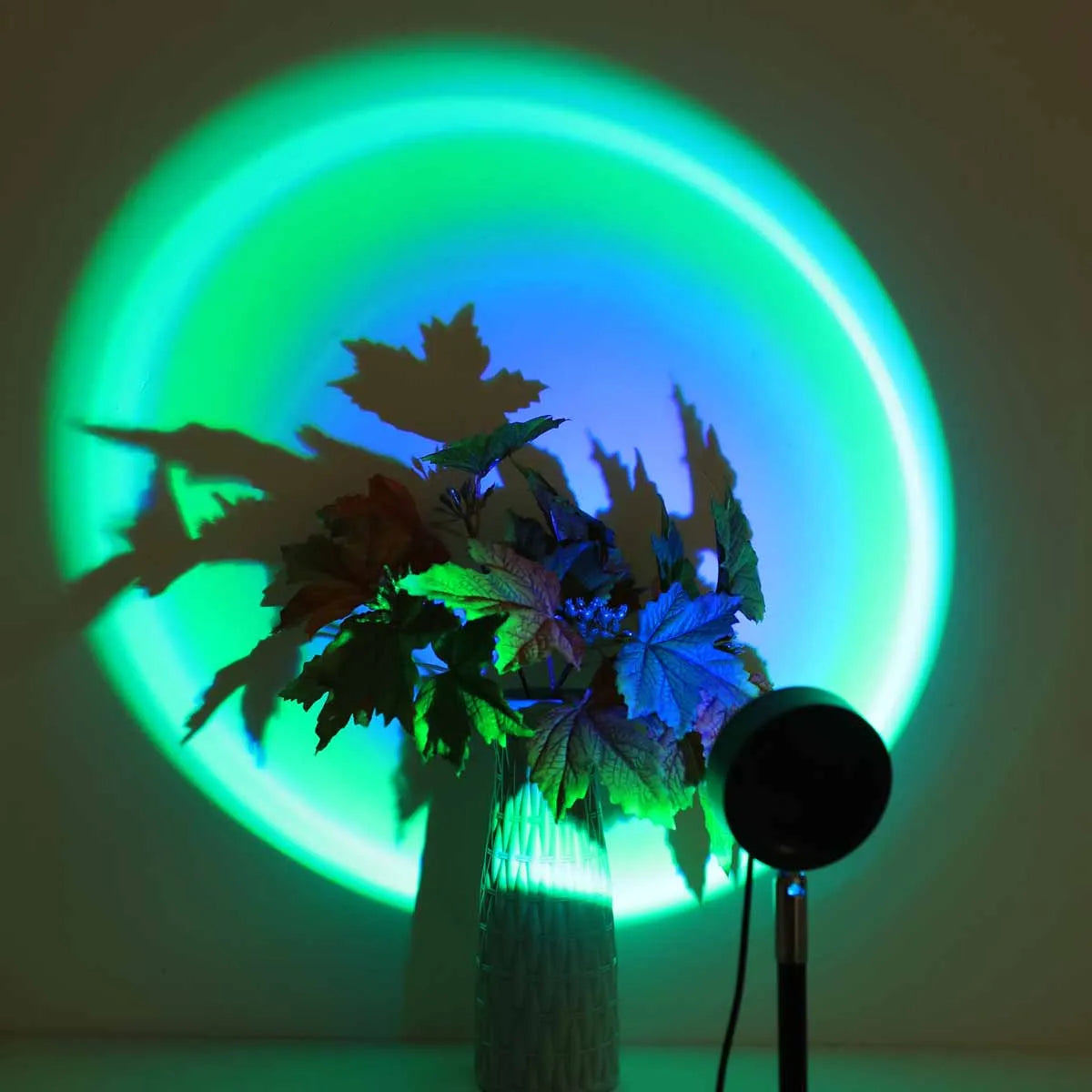 A plant is illuminated by a vibrant green light projected from a circular LED ring.