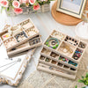 A light beige wooden jewelry storage tray filled with various gold and silver necklaces, rings, and earrings.
