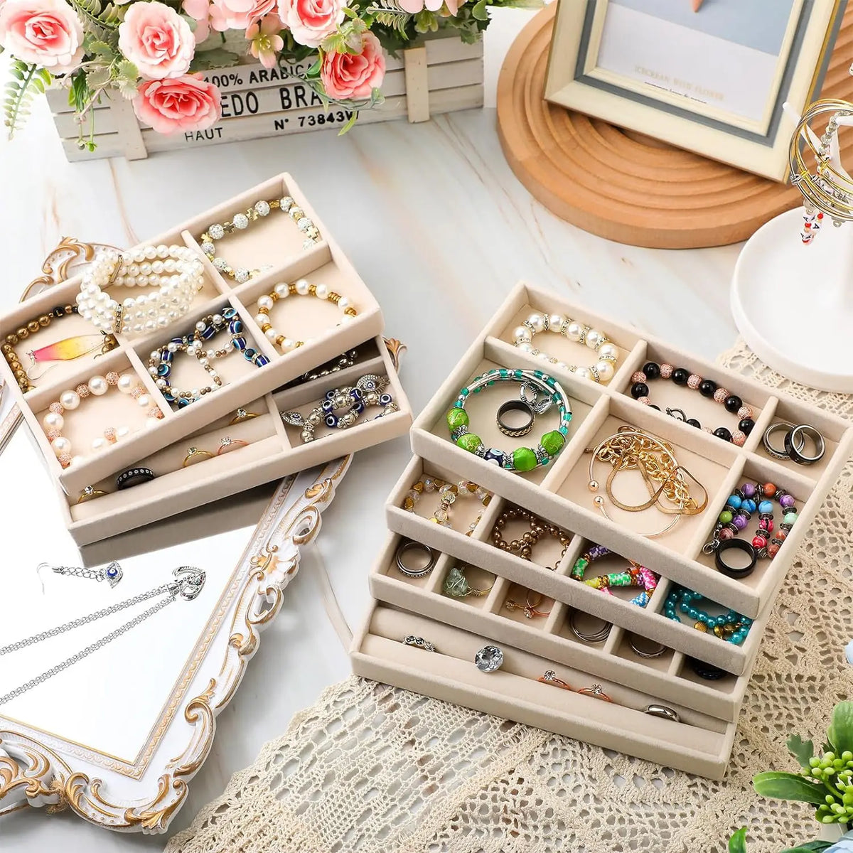 A light beige wooden jewelry storage tray filled with various gold and silver necklaces, rings, and earrings.