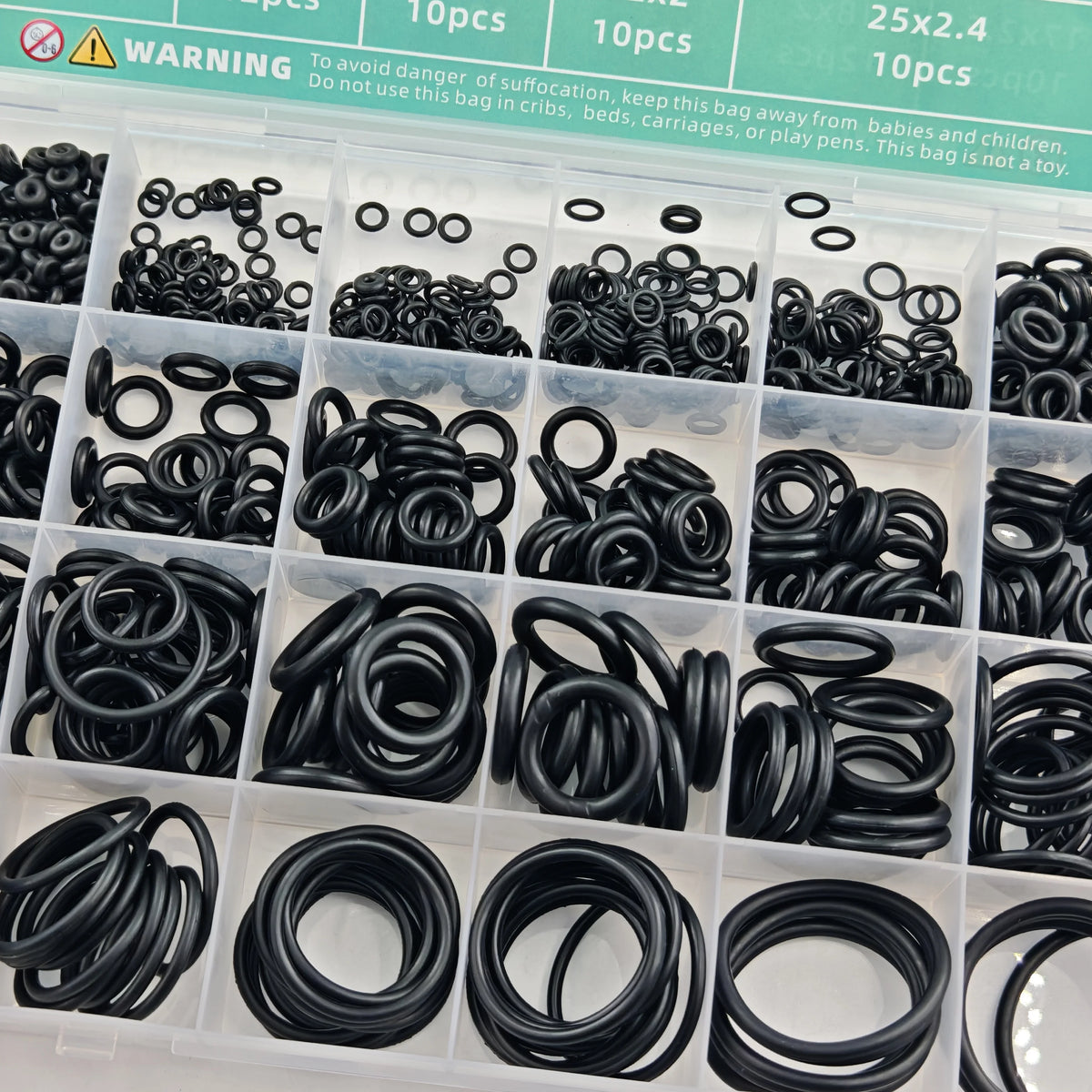 A plastic container filled with black nitrile O-rings and various sized rubber rings for repair kits.