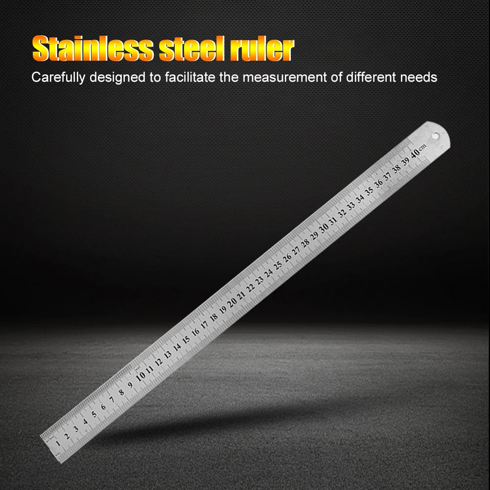 A stainless steel ruler showing markings up to 40 cm, laid diagonally on a dark surface.