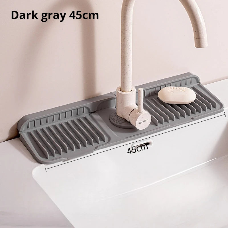 Dark gray silicone sink splash mat with a faucet and soap dish mounted on a white countertop