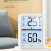 Termómetro digital y medidor de humedad blancos mostrando 25.0 °C y 60% de humedad sobre una superficie de madera.